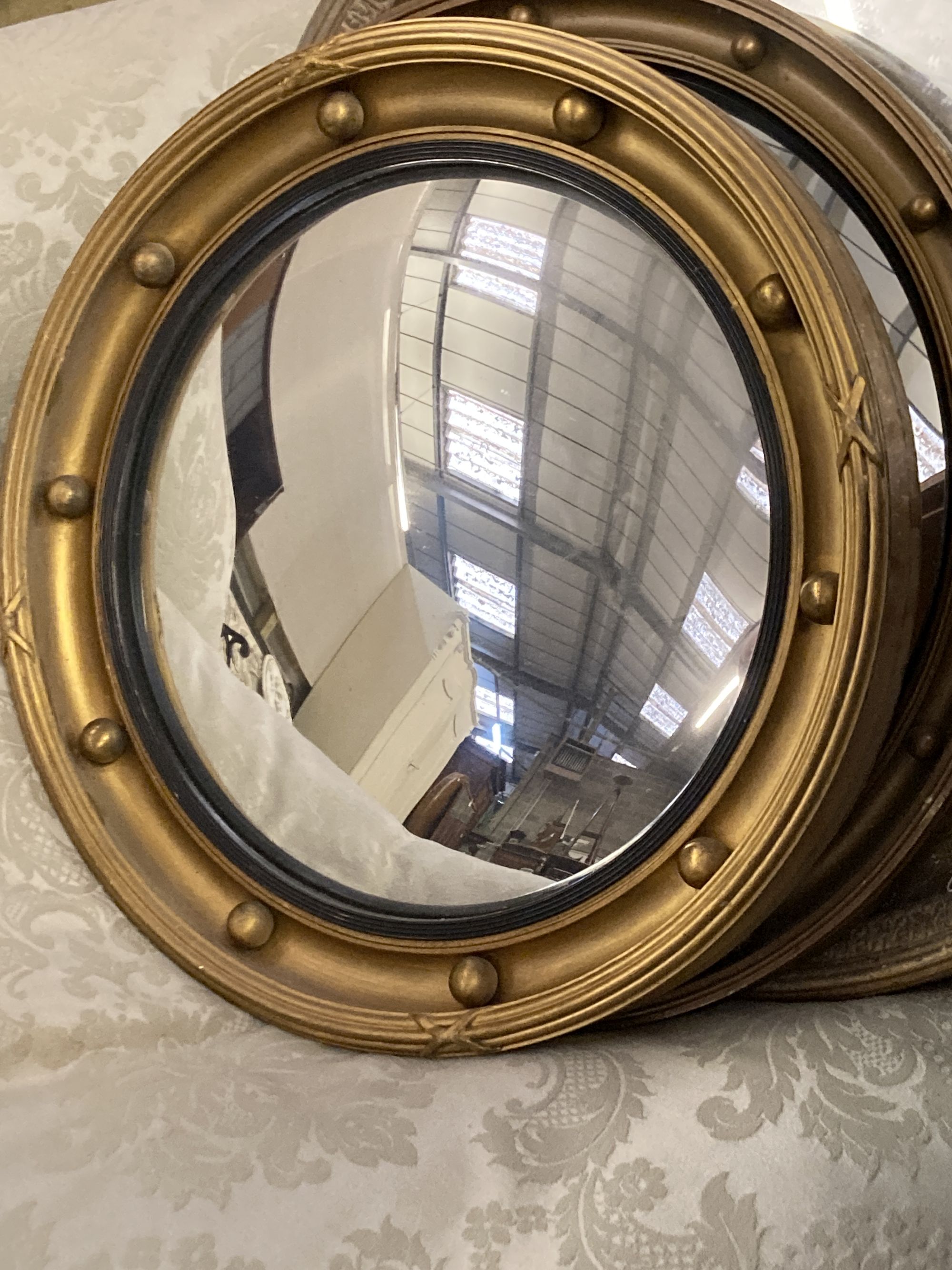 Four circular gilt framed convex and wall mirrors, largest 50cm diameter